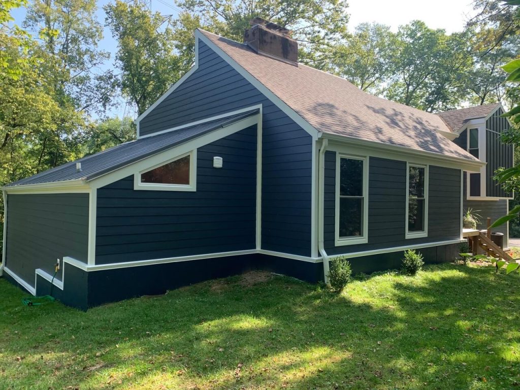 A finished house with dark blue lap siding and white trim