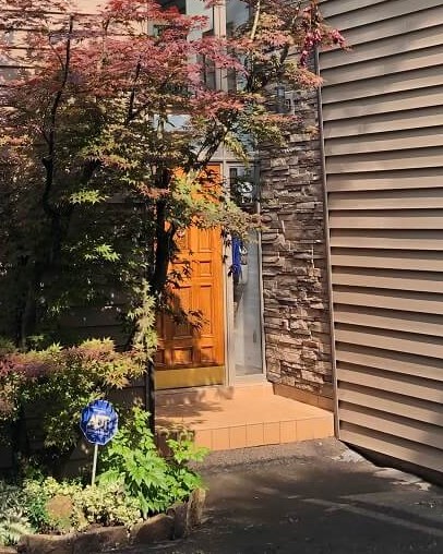 A new orange front door beside stone veneer and siding in Mt. Lookout